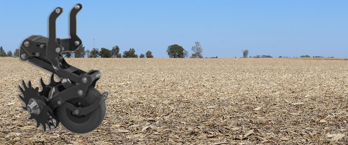 Reveal frame-mounted row cleaner with a harvested corn field in the background
